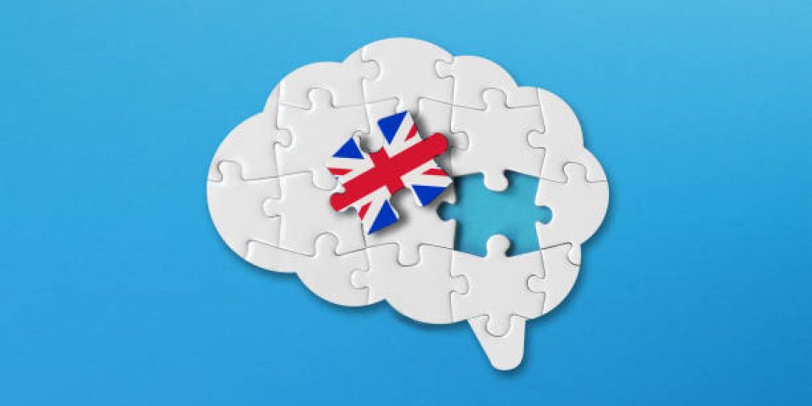 English learning concept, white jigsaw puzzle pieces with british flag a human brain shape on blue background