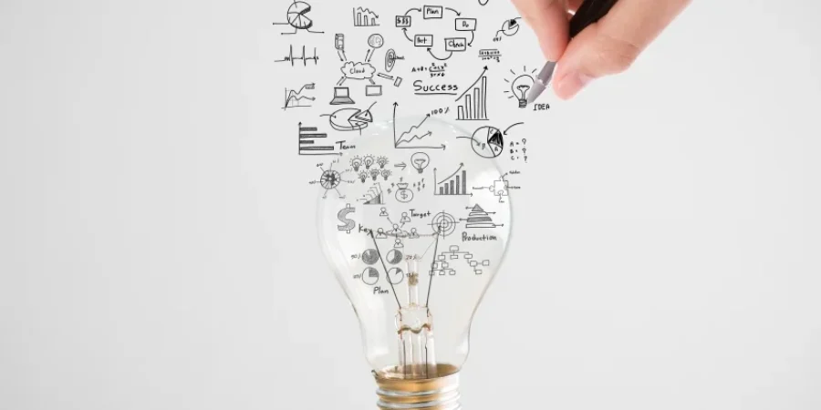 person-drawing-symbols-coming-out-light-bulb-top-book-1210x423.jpg